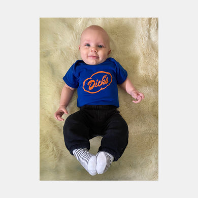 Baby wearing royal blue onesie with Dick's Drive-In orange cloud logo on front and black pants.