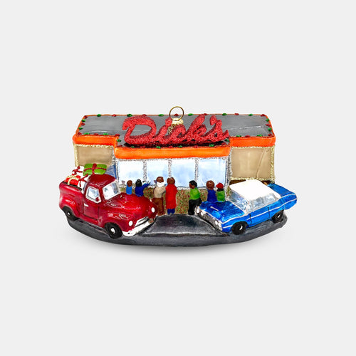 Front view of hand blown glass holiday ornament of Dick's Drive-In restaurant with classic red truck and blue car in front